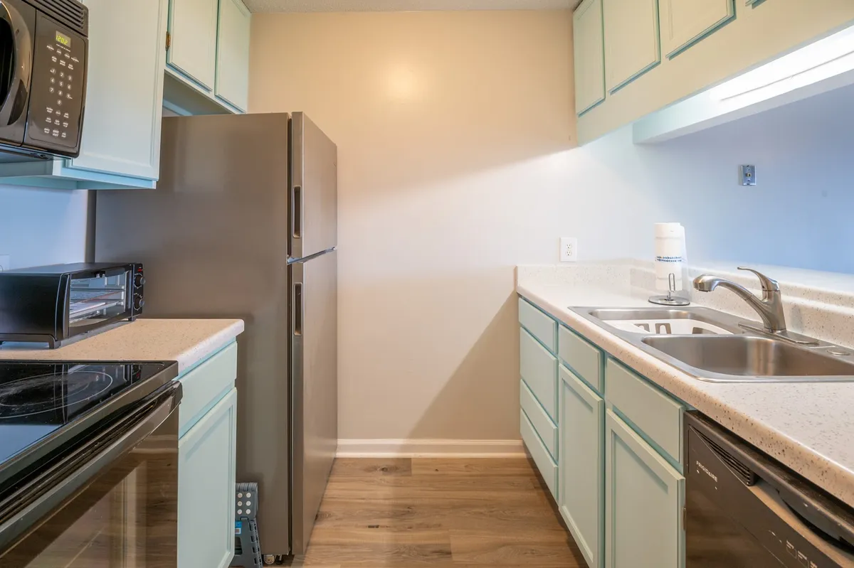 This image shows a well-equipped kitchen interior featuring modern appliances, sleek cabinetry, and a spacious sink area. The arrangement suggests ample workspace for meal preparation and a welcoming environment for cooking enthusiasts.